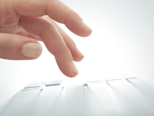 a close-up of a finger pointing at a computer screen