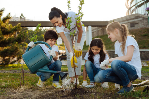 a person and several children planting a tree