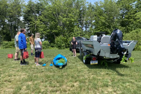 a group of people standing around a tractor in a field