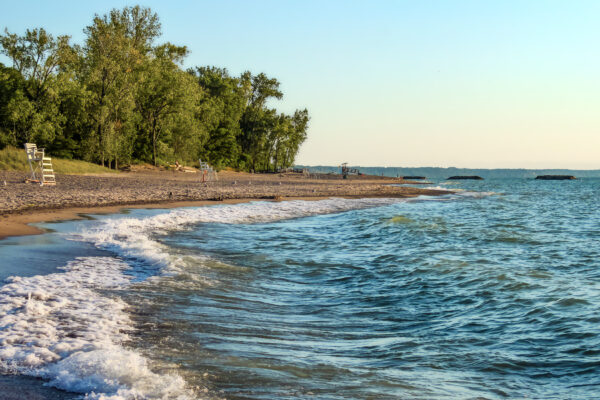 Deserted beach with lifeguard chairs and trees in background on Presque Isle on Lake Erie